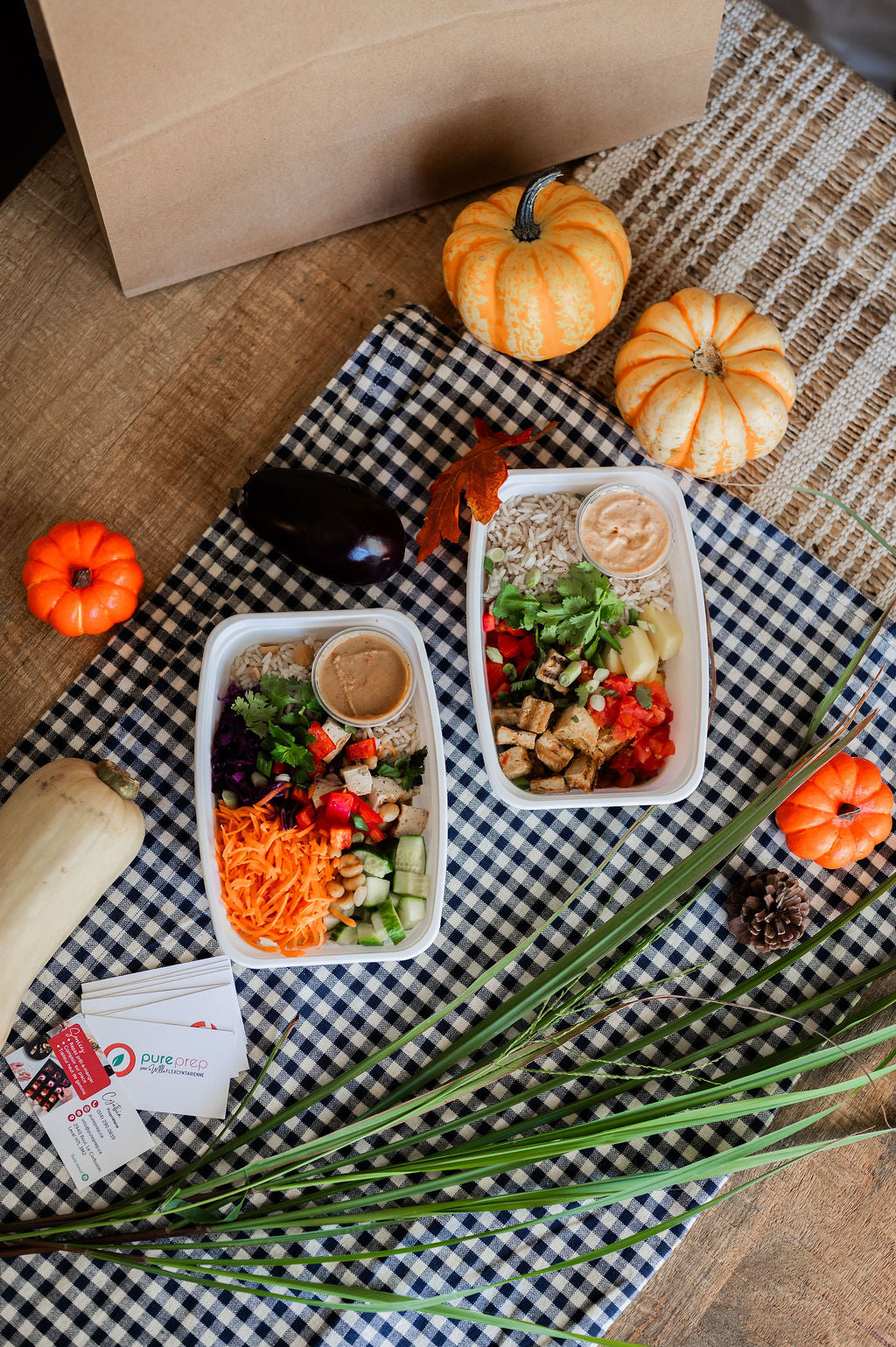 Repas Pureprep prêts à manger sur une nappe à carreaux, entourés de courges d’automne